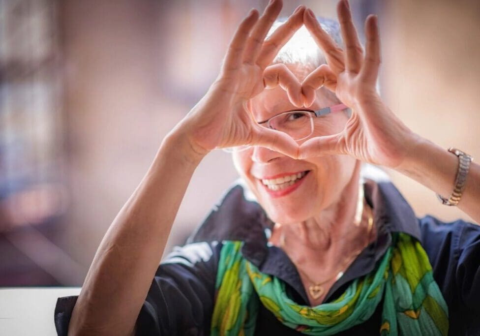 A woman making a heart with her hands.